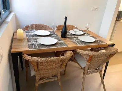 a wooden table with chairs and plates and wine glasses at Apartment Rafol in Vilanova i la Geltrú