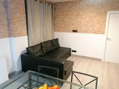 a living room with a couch and a glass table at La Fira - Paralelo 1 in Barcelona