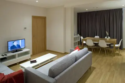 a living room with a couch and a dining room at Flateli Pelayo H1 in Barcelona
