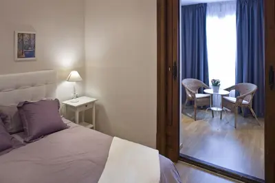 a bedroom with a bed and a table with chairs at Flateli Pelayo H1 in Barcelona