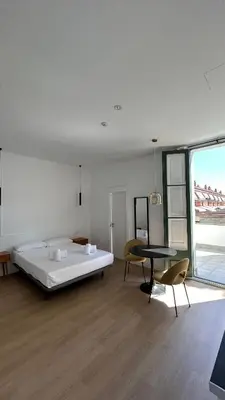 a bedroom with a bed and a table and chairs at Hotelito Boutique Badalona Gran Villa in Badalona