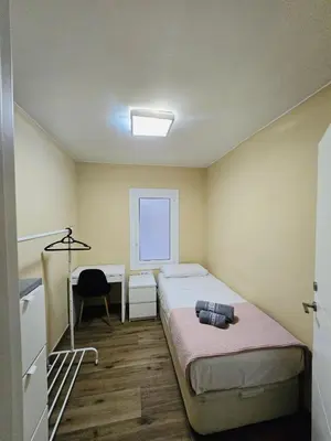 a bedroom with a bed and a desk and a window at Besos Apartment Barcelona in Sant Adria de Besos