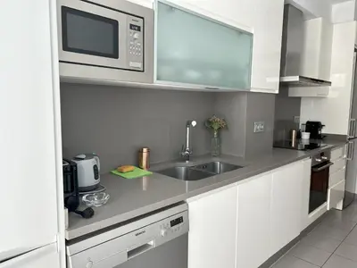 a kitchen with a sink and a microwave at Reina apartment in Sitges in Sitges