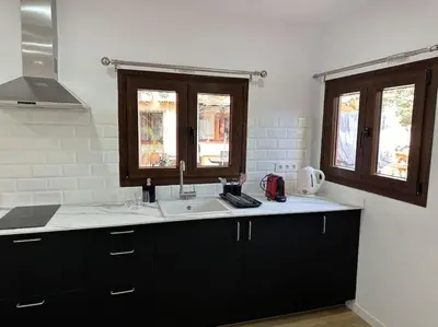 a kitchen with a sink and two windows at Casa de Invitados in La Floresta Pearson