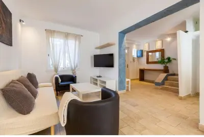 a living room with a couch and a tv at La Casita de Caldetes in Caldes d'Estrac