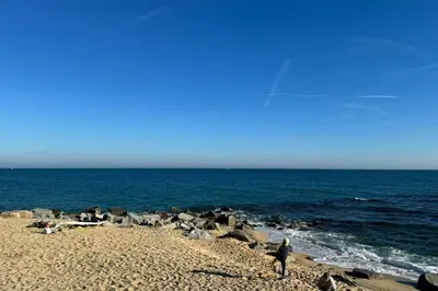 a person walking on a beach near the ocean at La Casita de Caldetes in Caldes d'Estrac