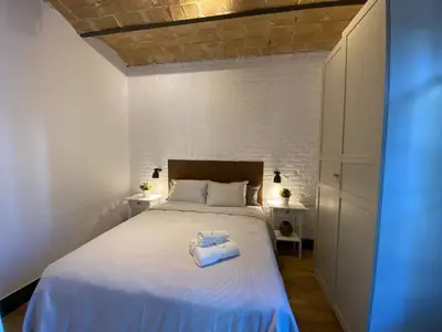 a bedroom with a bed with two towels on it at Barcelona Rent - Gaudi House in Barcelona