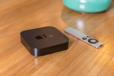 an apple remote control sitting on a wooden table at Plaza Catalunya City Center Apartments in Barcelona
