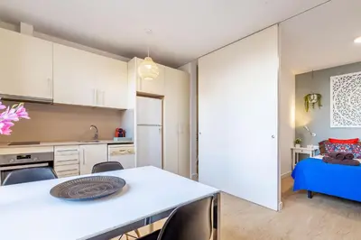 a kitchen and dining room with a white table and chairs at Modern Apartment 2 rooms 15' Bcn Center - Fira Barcelona in Barcelona