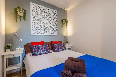a bedroom with a large bed with red and blue pillows at Modern Apartment 2 rooms 15' Bcn Center - Fira Barcelona in Barcelona