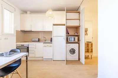 a kitchen with white cabinets and a washer and dryer at Modern Apartment 2 rooms 15' Bcn Center - Fira Barcelona in Barcelona