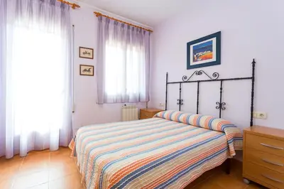 a bedroom with a bed with a striped comforter at Cal Vimón in Las Masucas