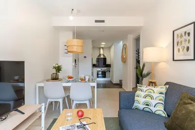 a living room with a blue couch and a kitchen at 4239 - AB Duplex Santa Coloma III in Santa Coloma