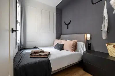a bedroom with a bed with pink pillows on it at Luxury Apt with King Beds & Central AC in Heart of BCN in Barcelona