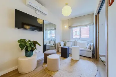 a living room with white furniture and a potted plant at Apartamento exclusivo en Sant Antoni in Barcelona