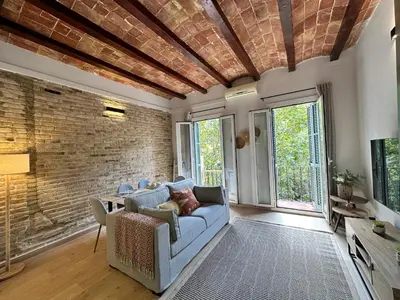 a living room with a blue couch and a brick wall at Sant Pau Modernista in Barcelona