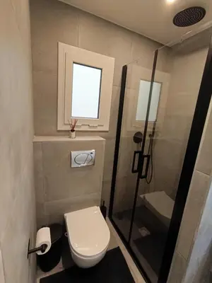 a small bathroom with a toilet and a shower at Mediterranean Bliss in Sant Adria de Besos