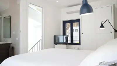 a small kitchen with white cabinets and a stove at Charming Casa in Sitges centre & minutes to beach in Sitges