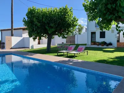 a swimming pool with two chairs and a house at Bed & Breakfast Wine & Cooking Penedès in Pla del Panadés