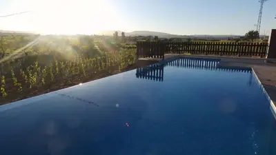 a large blue swimming pool with a wooden fence at Bed & Breakfast Wine & Cooking Penedès in Pla del Panadés