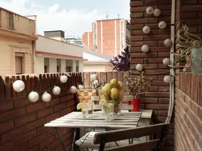 a table with a bowl of fruit on a brick wall at Renovated Apartment in Vila de Gràcia in Barcelona