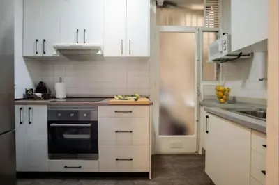 a kitchen with white cabinets and a stove top oven at Renovated Apartment in Vila de Gràcia in Barcelona
