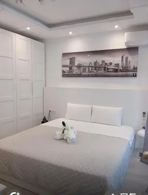 a teddy bear sitting on a bed in a bedroom at Warm Harbor in Santa Coloma de Gramanet