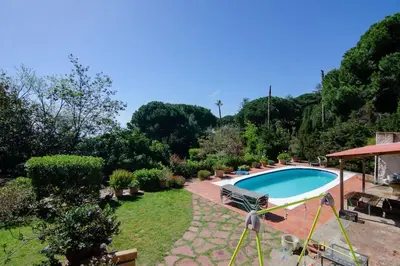 a patio with a pool and chairs and an umbrella at Mas Llavaneres in Sant Andreu de Llavaneres