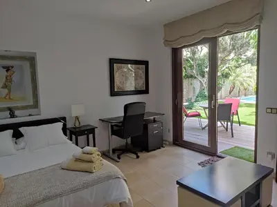 a bedroom with a bed and a desk and a patio at Alojamiento independiente de invitados el Olivo in El Prat de Llobregat