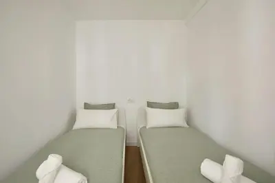 two beds in a room with white walls at 17 Nice apartment next to El Molino in Barcelona