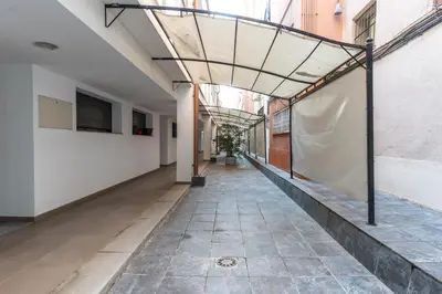 an empty corridor in a building with a glass ceiling at Acogedor apartamento Diagonal Mar in Barcelona
