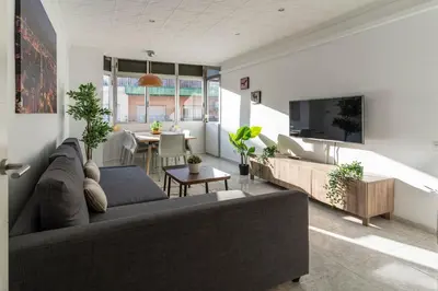 a living room with a couch and a tv at Bonito apartamento Camp Nou in Barcelona