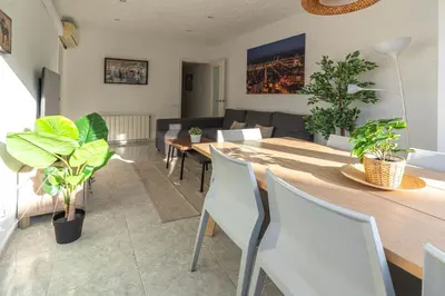 a living room with a table and chairs and a couch at Bonito apartamento Camp Nou in Barcelona