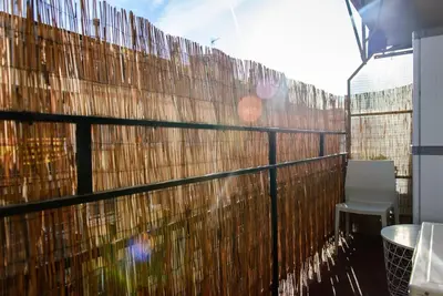 a balcony with a fence and a table and a chair at Bonito apartamento Camp Nou in Barcelona