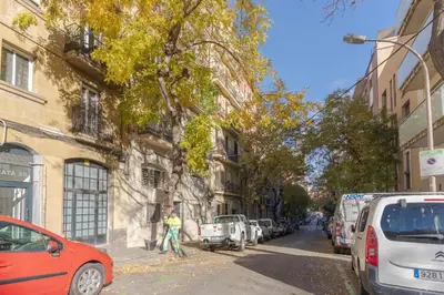 a man walking down a city street with cars parked at Lindo apartamento Montjuïc in Barcelona