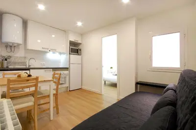 a kitchen and a living room with a table and a couch at Lovely and cozy apartments near Barcelona in Hospitalet de Llobregat