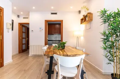 a dining room with a wooden table and white chairs at Magnífico apartamento en el centro in Barcelona
