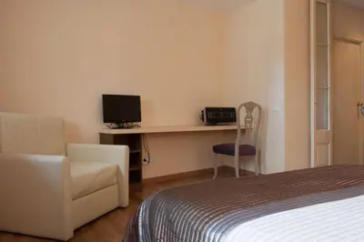 a bedroom with a bed and a desk with a television at EL born - spacious 2 bedrooms in Barcelona