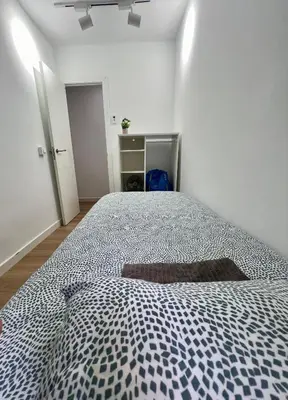 a bedroom with a bed with a blue and white comforter at Charming and quiet apartments near Barcelona in Hospitalet de Llobregat