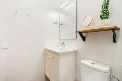 a white bathroom with a toilet and a sink at Lodging Apartments Almirall Beach B2 in Barcelona