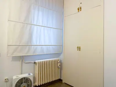 a room with a radiator and a window with a curtain at Apartment Vicente in Vilanova i la Geltrú