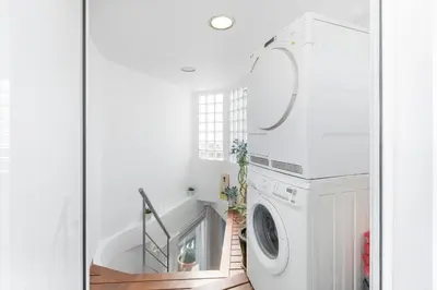 a white laundry room with a washer and dryer at Esencia Mediterránea Precioso en primera linea in Sitges