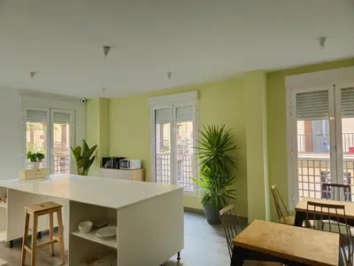 a kitchen with green walls and a table and chairs at HeyLola! Hostel in Barcelona