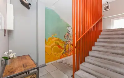 a hallway with a staircase with a painting on the wall at HeyLola! Hostel in Barcelona