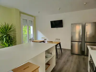 a kitchen with a white counter top and a refrigerator at HeyLola! Hostel in Barcelona