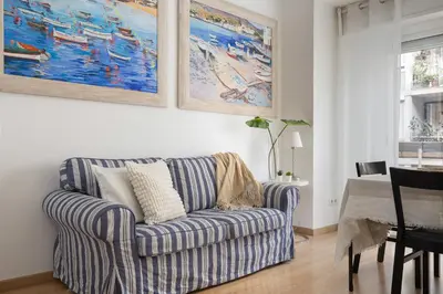 a living room with a blue and white striped couch at Lets Holidays Centric Apartment in Barcelona in Barcelona