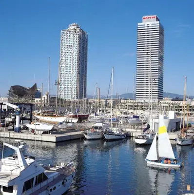 a group of boats docked in a marina with tall buildings at Lets Holidays Centric Apartment in Barcelona in Barcelona