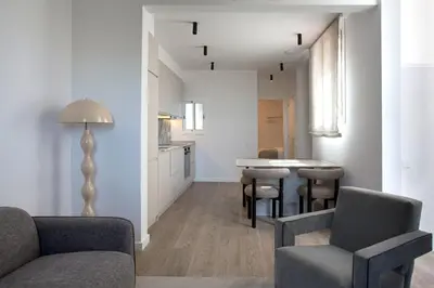 a living room with a couch and chairs and a table at The Diagonal Suites Atic by Sweett in Barcelona