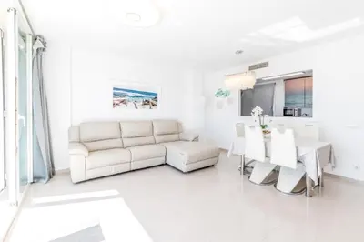 a white living room with a couch and a table at Frente a mar salida directa playa solo 30M agua in Cubelles