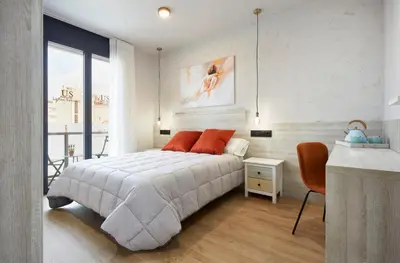 a bedroom with a bed with orange pillows on it at Urban Sabadell 2 in Sabadell